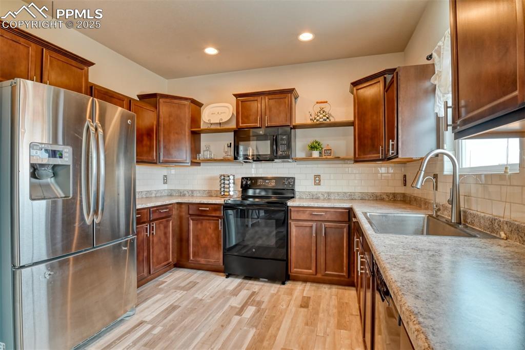 Undisclosed Address Peyton, CO 80831 - Photo 4 of 50 a kitchen with stainless steel appliances granite countertop a refrigerator a sink dishwasher a stove with wooden cabinets and floor