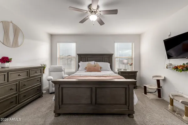 a bedroom with a bed and a flat tv screen on dresser