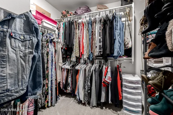 a view of walk in closet with clothes