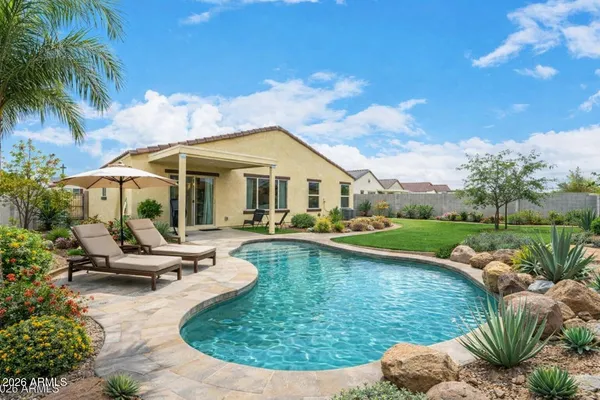 a view of a house with swimming pool and sitting area