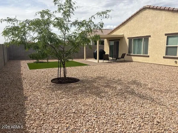 a view of a house with backyard and tree