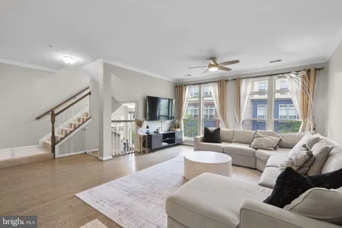 a living room with furniture flat screen tv and a large window