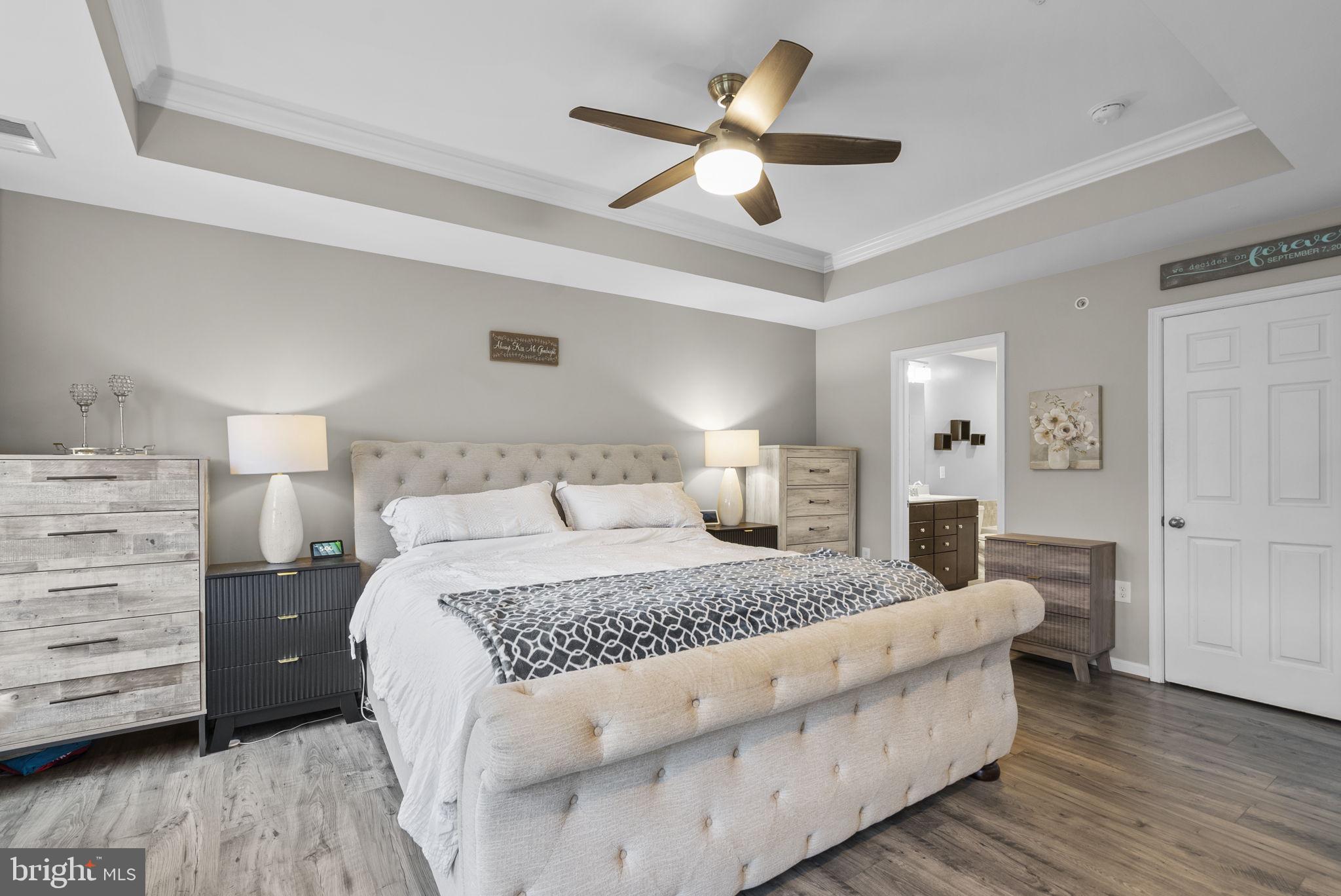 121 Copley Circle, Unit 34B Gaithersburg, MD 20878 - Photo 25 of 43 a bedroom with a large bed and a chandelier