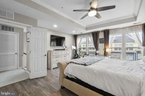 a spacious bedroom with a bed and a flat screen tv