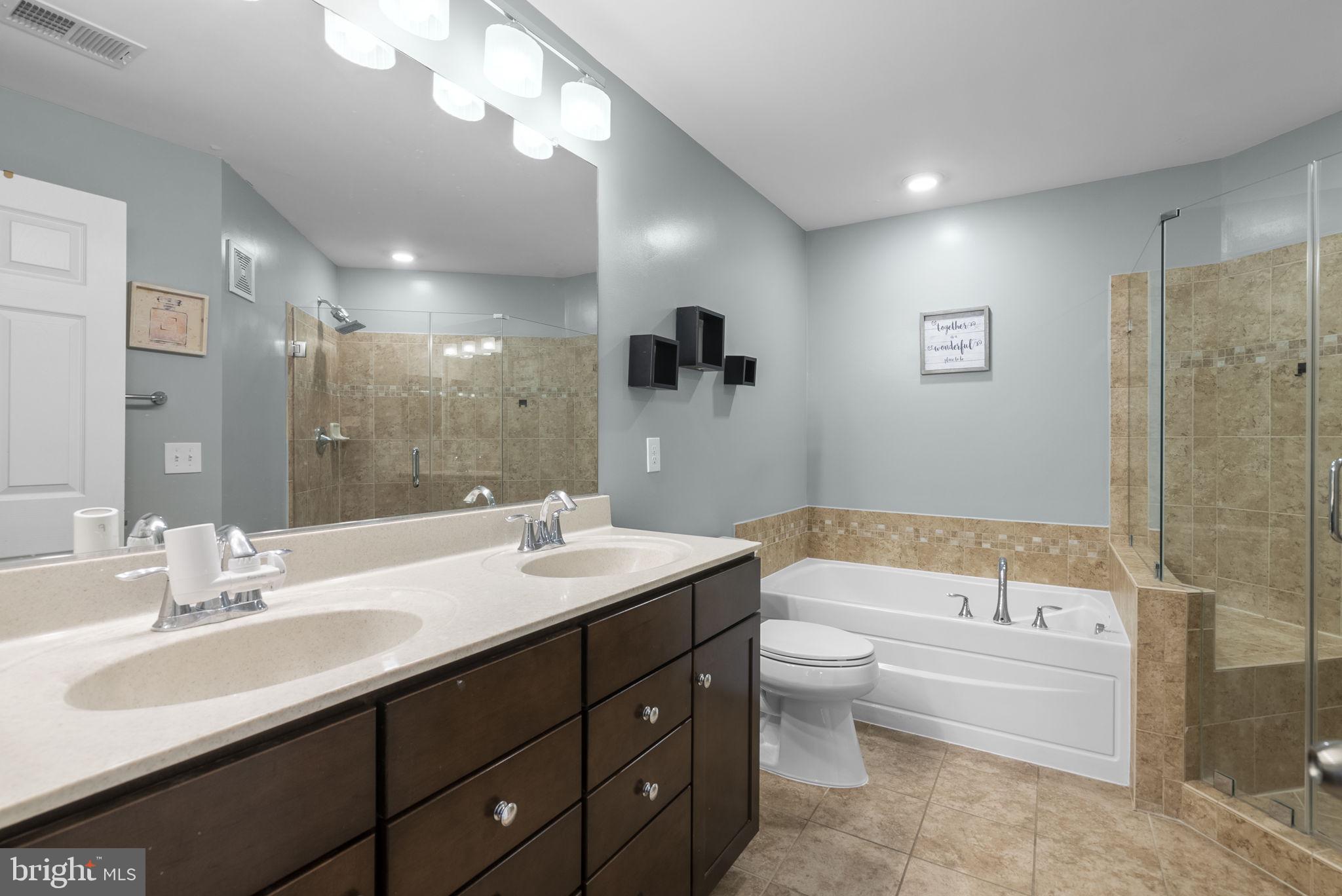 121 Copley Circle, Unit 34B Gaithersburg, MD 20878 - Photo 28 of 43 a bathroom with a double vanity sink toilet mirror and bathtub