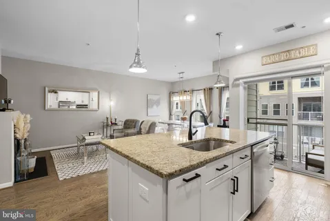 a kitchen with granite countertop a sink a center island and cabinets