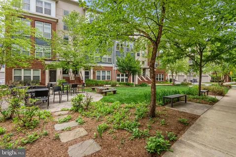 a view of a patio with table and chairs and potted plants and large trees