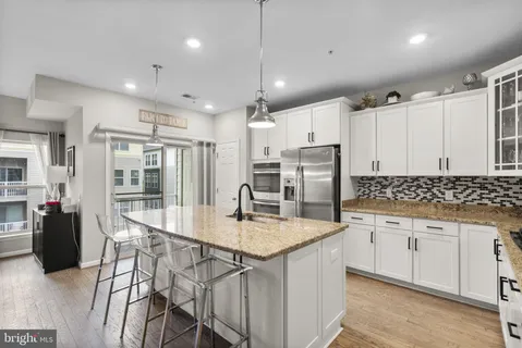 a kitchen with stainless steel appliances granite countertop a sink refrigerator and cabinets