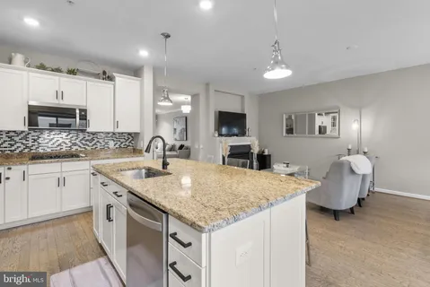 a kitchen with granite countertop kitchen island a sink appliances and cabinets