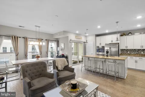 a large living room with stainless steel appliances granite countertop a couch and a view of kitchen