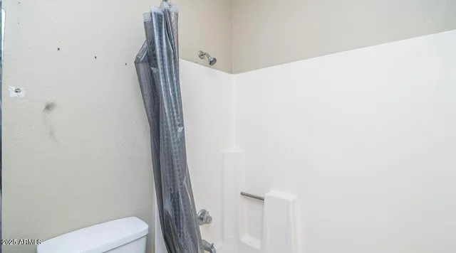 a bathroom with a toilet and a shower