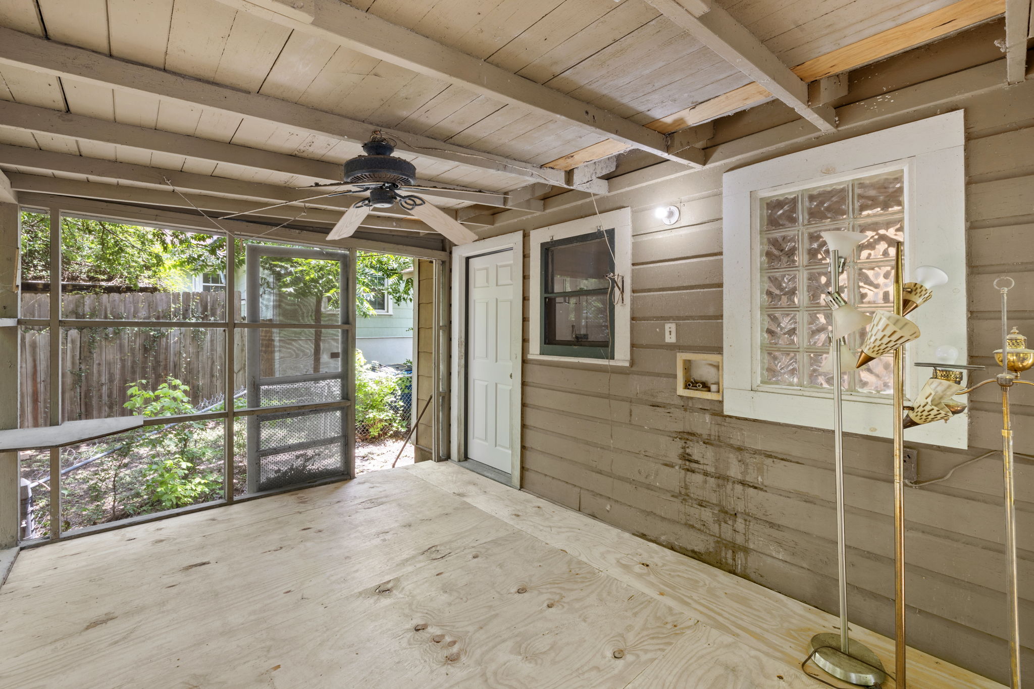 3704 Cherrywood Road Austin, TX 78722 - Photo 31 of 40 An enclosed screened back porch with a wooden ceiling and ceiling fan.