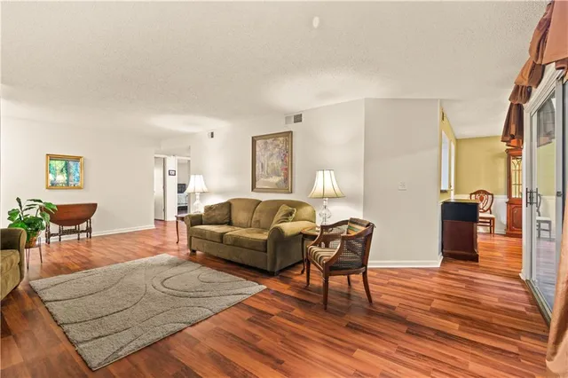 a living room with furniture a dining table and wooden floor