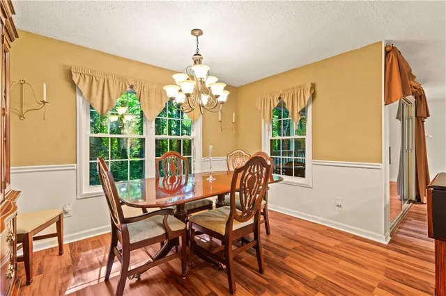 a view of a dining room with furniture wooden floor and chandelier