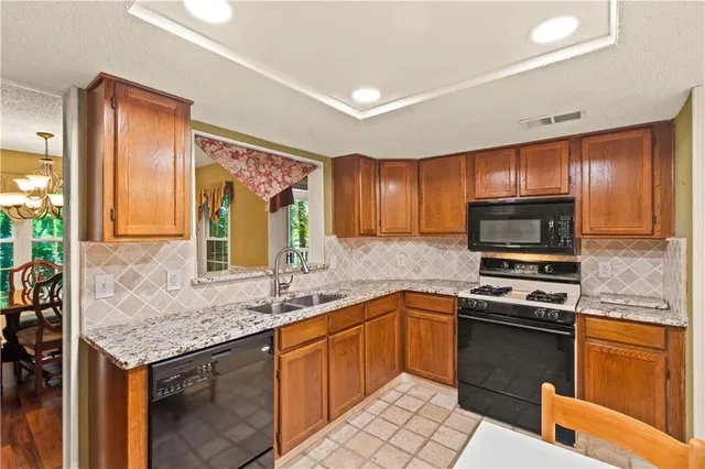a kitchen with a sink stove top oven and refrigerator