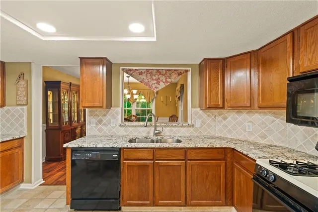 a kitchen with granite countertop cabinets stainless steel appliances and a counter space
