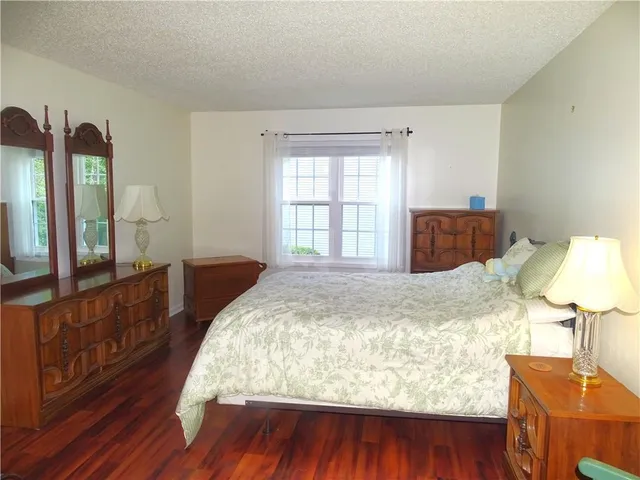 a bed sitting in a bedroom next to a window with dresser