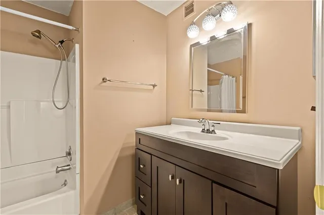 a bathroom with a sink vanity mirror and shower