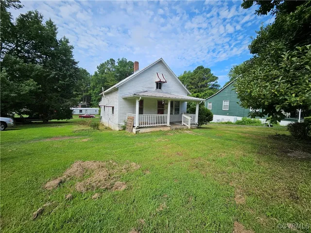 a front view of a house with a yard and trees