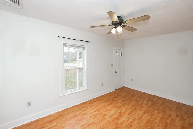 wooden floor in an empty room with a window