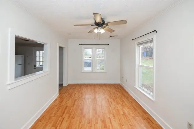 a view of a big room with wooden floor and windows
