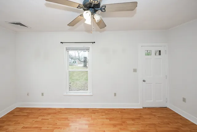 an empty room with windows and fan