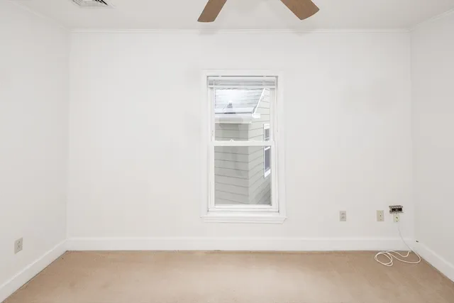 an empty room with a window and a fan