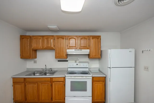 a kitchen with stainless steel appliances granite countertop a refrigerator a stove a sink dishwasher and a microwave