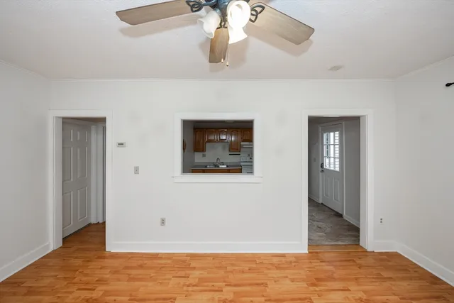 a view of a room with a ceiling fan and a window