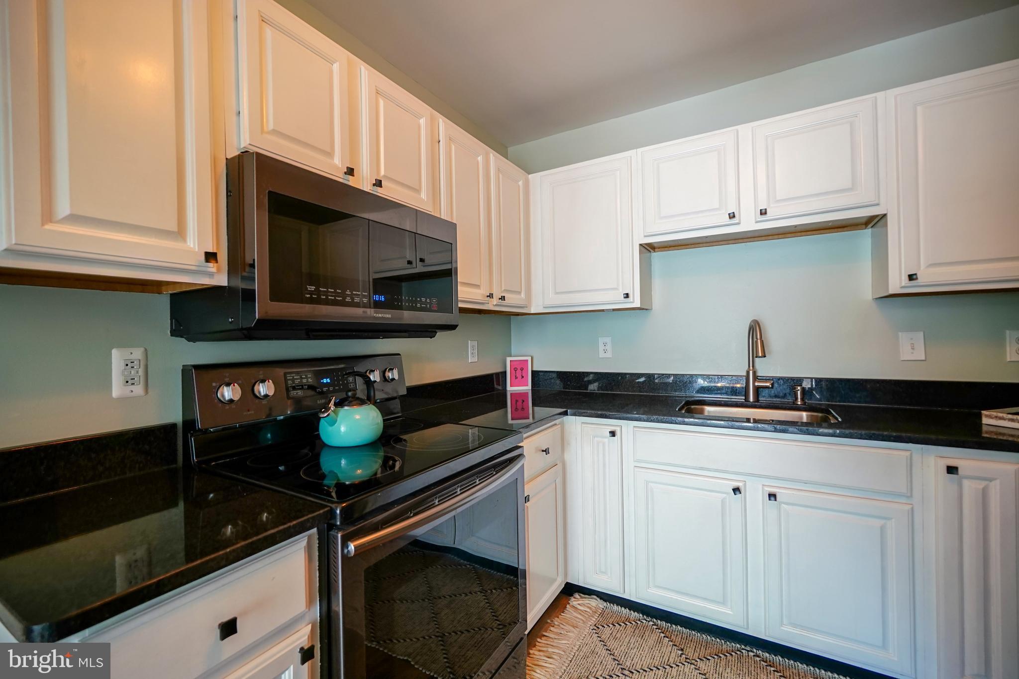 112 Lakeside Drive Lewes, DE 19958 - Photo 11 of 31 a kitchen with white cabinets and appliances