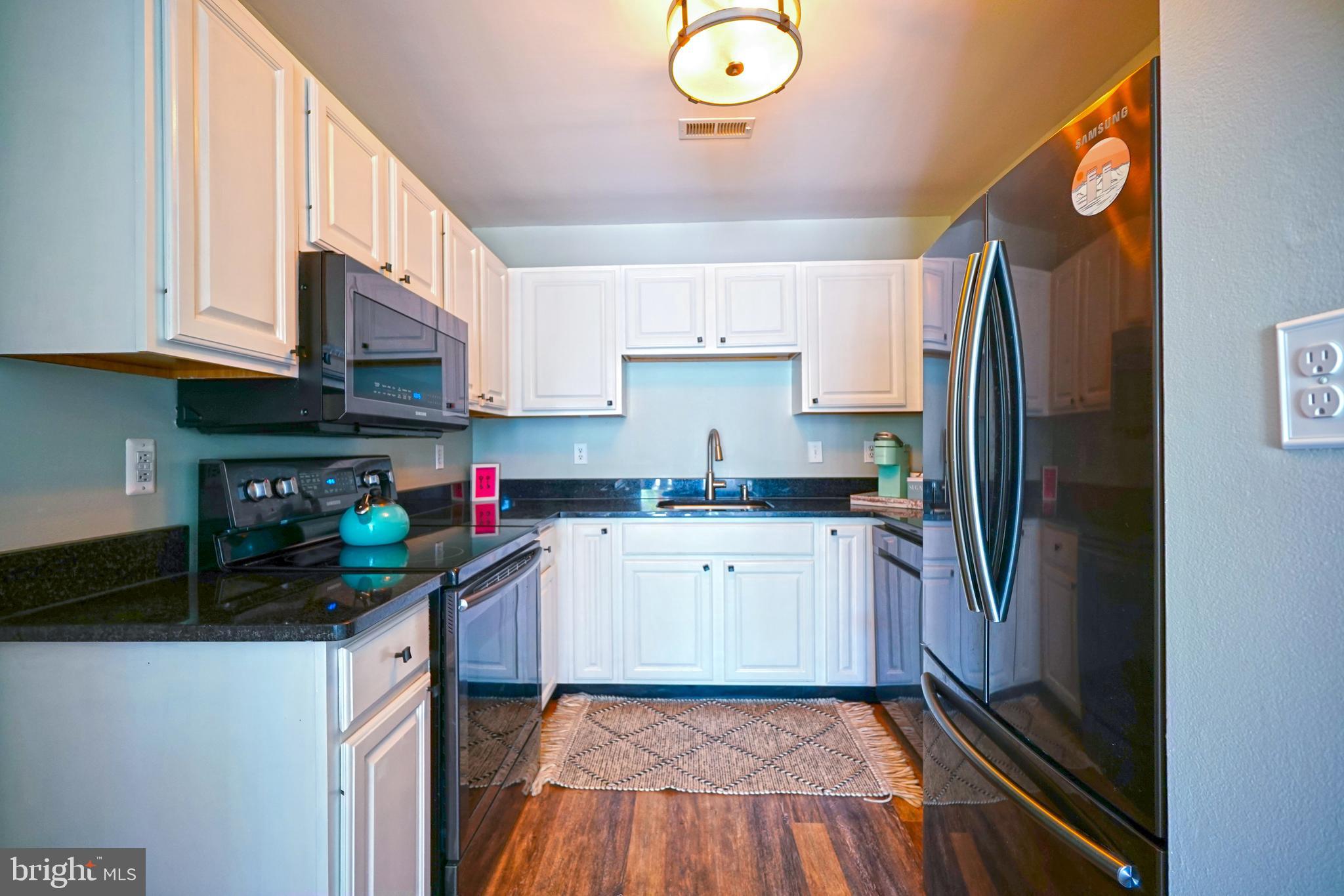 112 Lakeside Drive Lewes, DE 19958 - Photo 10 of 31 a kitchen with a sink a refrigerator and cabinets