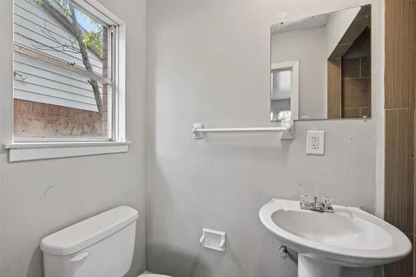 a bathroom with a toilet a sink and mirror