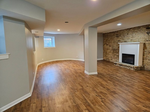 4012 North Sheridan Road, Unit GN Chicago, IL 60613 - Photo 2 of 13 an empty room with wooden floor and fireplace