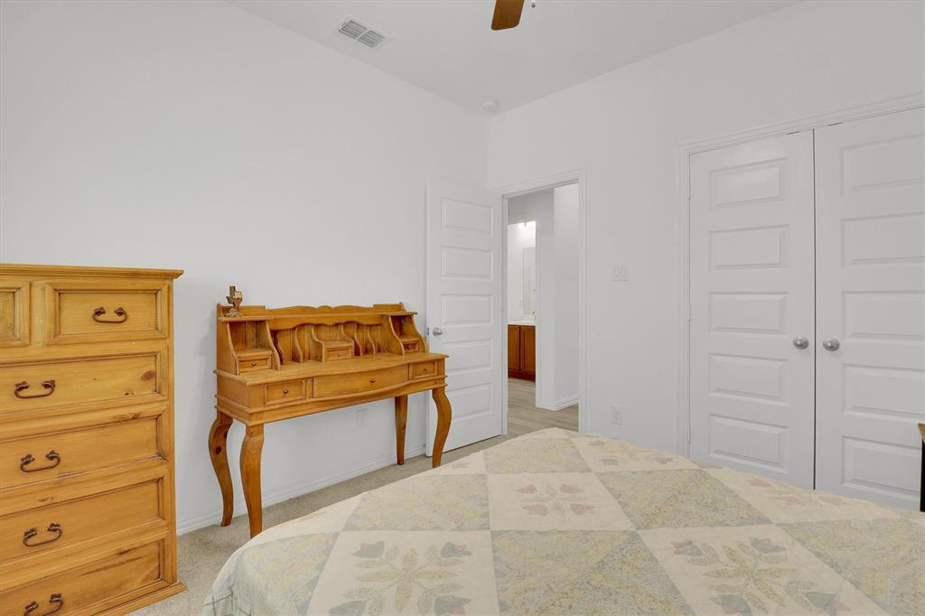 1446 Whitewater Drive Little Elm, TX 75068 - Photo 14 of 35 a bedroom with a bed and a cabinets
