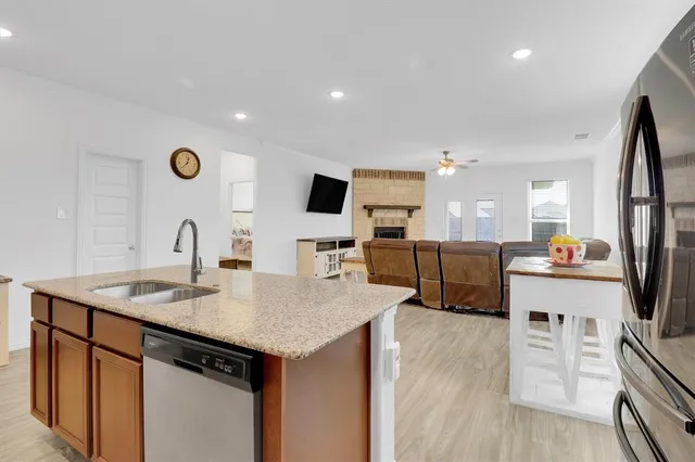 a kitchen with stainless steel appliances granite countertop a sink stove and refrigerator