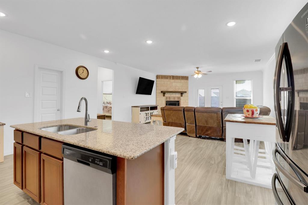 1446 Whitewater Drive Little Elm, TX 75068 - Photo 20 of 35 a kitchen with stainless steel appliances granite countertop a sink a stove and a refrigerator