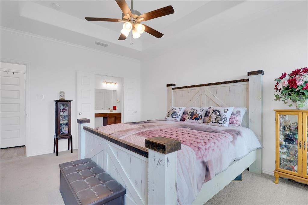 1446 Whitewater Drive Little Elm, TX 75068 - Photo 28 of 35 a bedroom with a bed and a chandelier