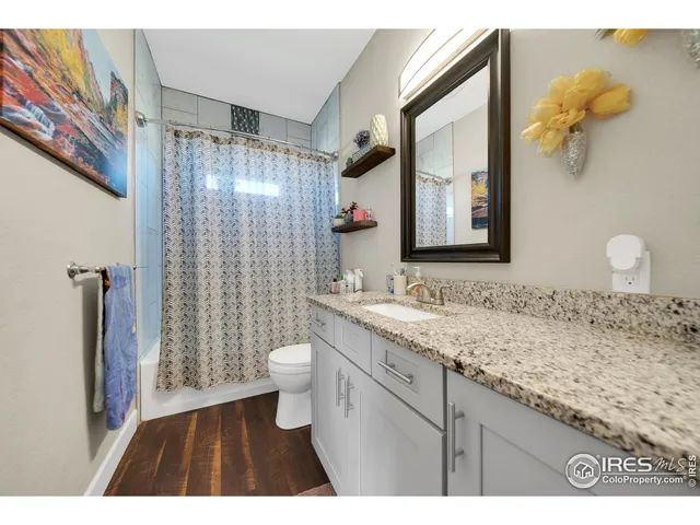 a bathroom with a granite countertop sink toilet and shower