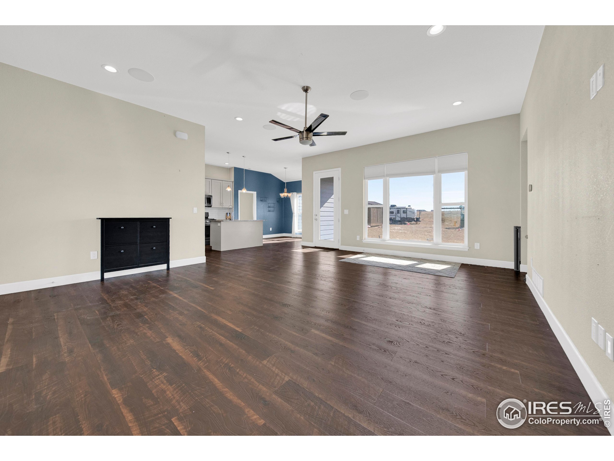 7566 County Road Wiggins, CO 80654 - Photo 4 of 23 a view of an empty room with window and wooden floor