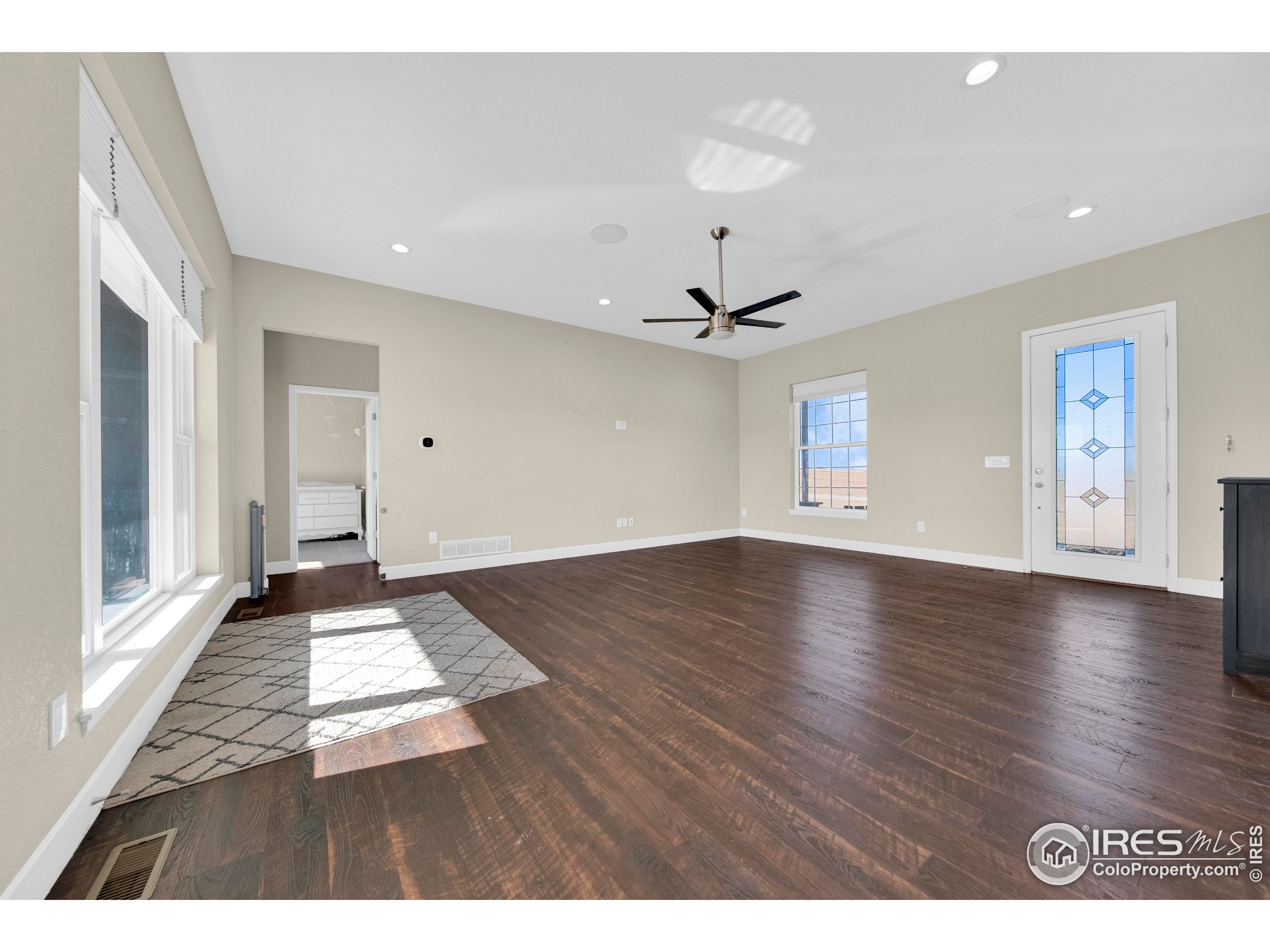 7566 County Road Wiggins, CO 80654 - Photo 5 of 23 a view of an empty room with window and wooden floor