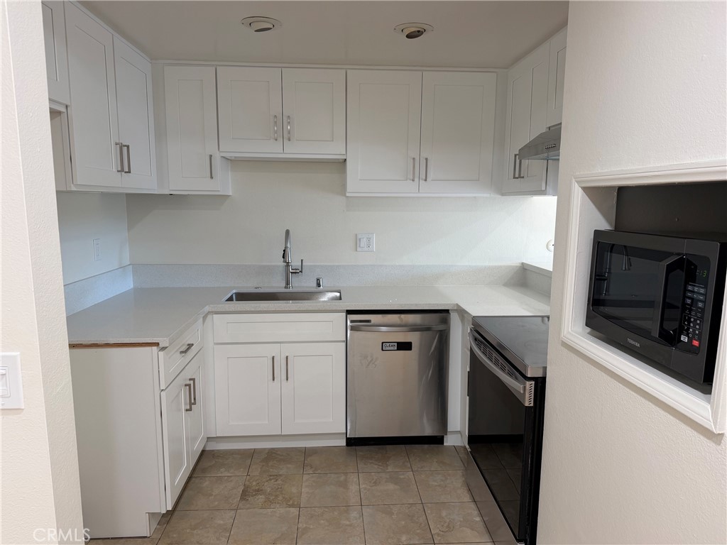 3054 Associated, Unit 26 Fullerton, CA 92835 - Photo 6 of 27 a kitchen with white cabinets and appliances