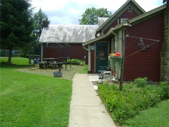a front view of a house with a garden and trees