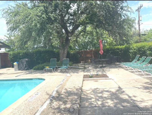 a view of a yard with table and chairs and wooden fence