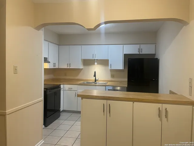 a kitchen with granite countertop a stove and a sink