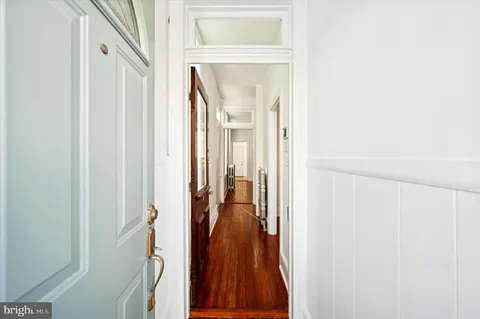 a view of a hallway with a livingroom and a dinning area with glass door