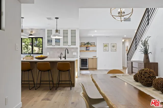 a dining hall with stainless steel appliances kitchen island granite countertop furniture and wooden floor