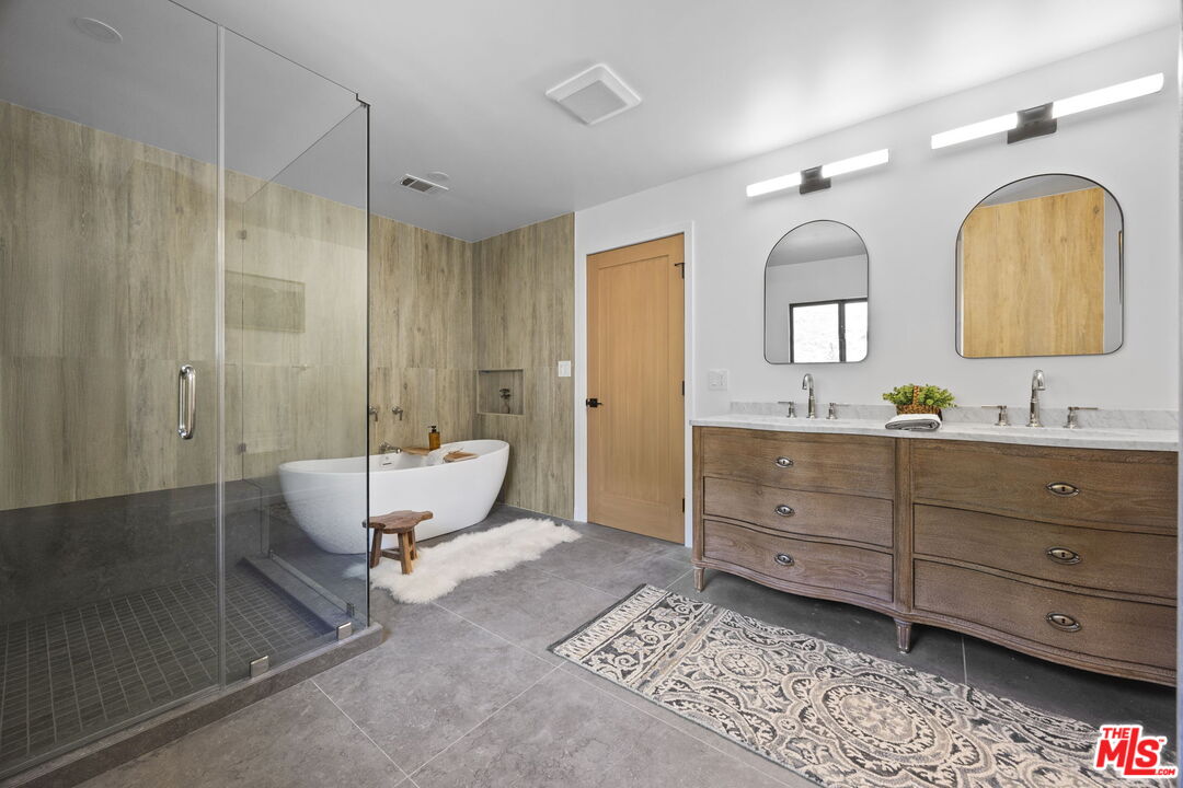 1131 Rancho Drive Ojai, CA 93023 - Photo 36 of 58 a spacious bathroom with a granite countertop tub sink a mirror a shower and vanity