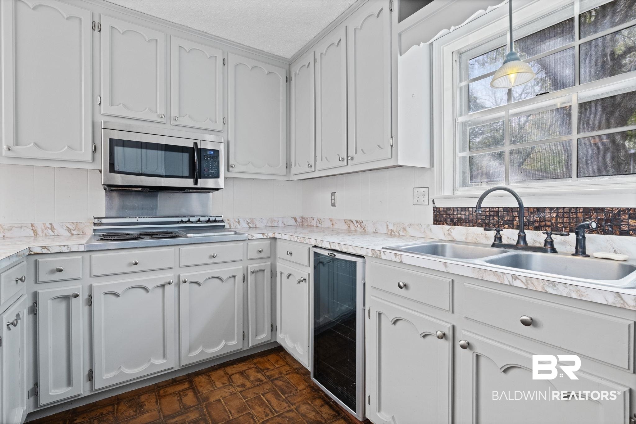 6261 Old Pascagoula Road Theodore, AL 36582 - Photo 16 of 29 Kitchen with hanging light fixtures, white cabinetry, sink, and beverage cooler