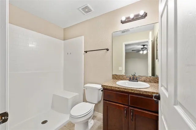 a bathroom with a sink a toilet a mirror and shower