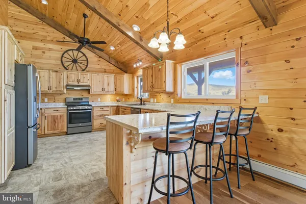 a kitchen with stainless steel appliances granite countertop a stove a table and chairs in it